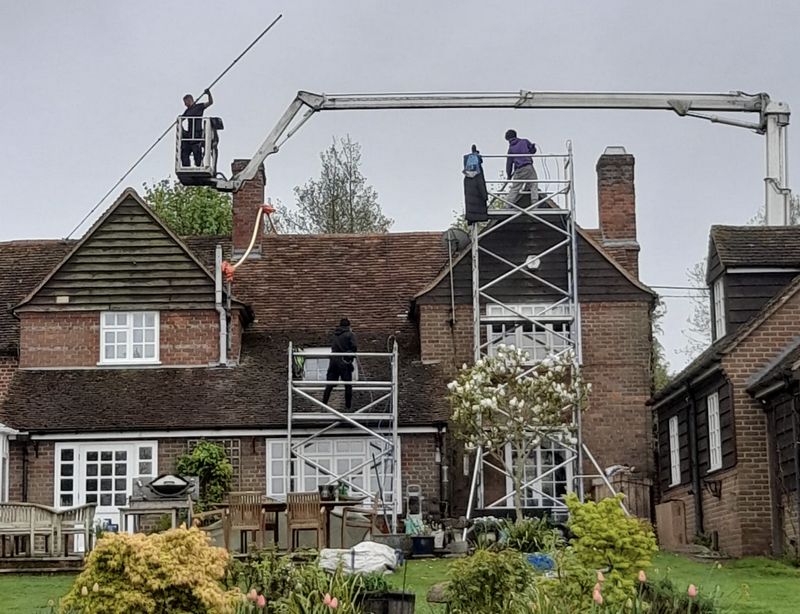 The Roof Moss Cleaners using cherry picker and scaffolding to clean roof safely and professionally in Midhurst, West Sussex